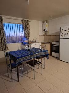 eine Küche mit einem blauen Tisch und Stühlen sowie einem Kühlschrank in der Unterkunft Tierra Viva Solor Cabañas in Sólor