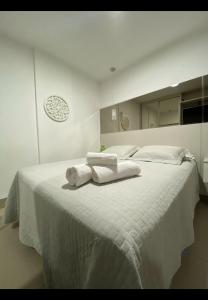 - une chambre blanche avec 2 serviettes blanches sur un lit dans l'établissement Studio moderno, à Uberlândia 13 autres photos