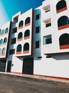 a white building with windows on the side of it at Solena Apartamentos Tacna in Tacna