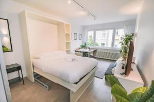 een slaapkamer met een bed, een bureau en een raam bij Stylish Studio in the Heart of Luxembourg City in Luxemburg
