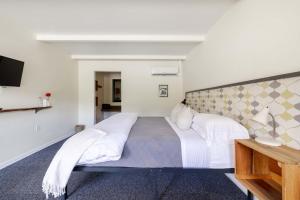 a bedroom with a large bed and a television at The Billy Motel King Room with Retro Charm in Davis