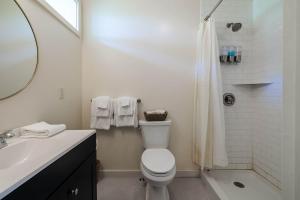 a white bathroom with a toilet and a shower at The Billy Motel King Room with Retro Charm in Davis
