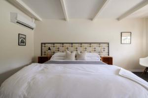 a bedroom with a large white bed with pillows at The Billy Motel King Room with Retro Charm in Davis