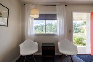 two white chairs in a room with a window at The Billy Motel King Room with Retro Charm in Davis