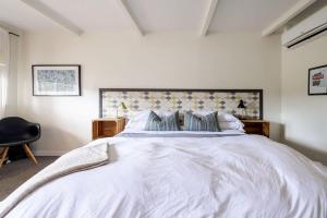 a bedroom with a white bed and a black chair at The Billy Motel Pet Friendly Room with Charm in Davis