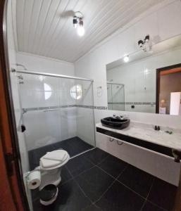 een badkamer met een toilet, een wastafel en een spiegel bij Pousada da Lua in Campos do Jordão +77 foto's