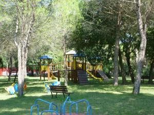 a park with a playground with a slide and trees at Mobilehome in Belvedere Grado 53452 in Belvedere