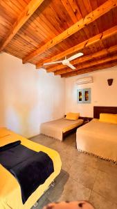 Zimmer mit 3 Betten und Holzdecke in der Unterkunft Wanasa House in Saint. Catherine