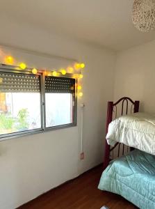 a bedroom with a bed and a window with lights at Casa, gran parrillero a pocos minutos de sitios turísticos in Minas