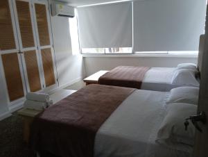 a hotel room with two beds and a window at Toscana Suite 2 D in Estación El Salto