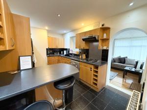 eine Küche mit einer Theke und ein Wohnzimmer in der Unterkunft Stylish 4-Bedroom Home with Modern Comforts in Derby