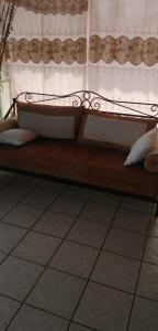 un banc en bois assis dans une pièce avec des rideaux dans l'établissement Casa Vergel, à Temixco 6 autres photos