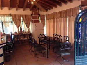 une pièce avec des chaises, une table et un réfrigérateur dans l'établissement Casa Vergel, à Temixco