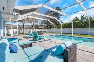 a patio with a pool and chairs and a swimming pool at Marco Island Pool, Spa Getaway Fenced Pet Friendly in Marco Island