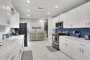 a kitchen with white cabinets and a black refrigerator at Marco Island Pool, Spa Getaway Fenced Pet Friendly in Marco Island