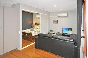 a living room with a couch and a bedroom at Stylish Studio 1x1 Walk to CBD in Port Hedland