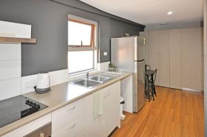 a kitchen with a sink and a refrigerator at Stylish Studio 1x1 Walk to CBD in Port Hedland +2 photos
