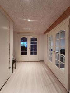 an empty room with white walls and doors at Seperat lejlighed i stueetage in Sisimiut
