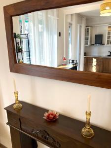 a mirror above a wooden table with two candles at Charming king studio with balcony and jacuzzi in Como +15 photos