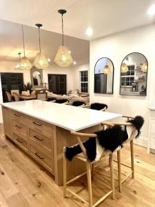a kitchen with a large white counter and chairs at Charming Victoria Character Home-Pet Friendly in Victoria