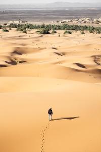 Tioukougne PeulにあるLompoul Natureの砂漠を歩く人