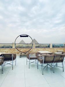 una mesa y sillas en una azotea con vistas a las pirámides en Pyramids Hotel & Free pickup shuttle, en El Cairo