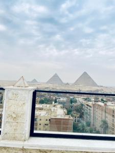Una vista de las pirámides desde una ventana en las pirámides en Pyramids Hotel & Free pickup shuttle, en El Cairo