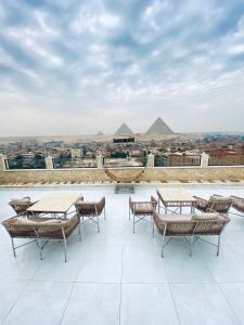 un patio con mesas y sillas en la parte superior de un edificio en Pyramids Hotel & Free pickup shuttle, en El Cairo