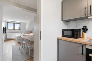 a kitchen and dining room with a table and a microwave at Modern Limpertsberg Studio Near City Center in Luxembourg