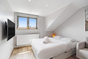 a white bedroom with a large bed and a couch at Modern Limpertsberg Studio Near City Center in Luxembourg