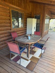 a wooden table and chairs on the porch of a cabin at Lake Whitney Log Cabin in Lakewood Harbor +27 photos