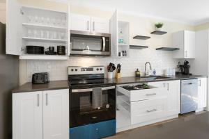 a white kitchen with a stove and a microwave at Elegant 2 Story Bloomfield 3 Kings 2 Queens in Bloomfield +40 photos