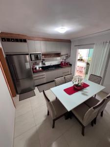 a kitchen with a table and chairs and a refrigerator at Casa de Praia in Penha