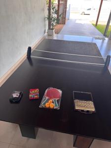 a ping pong table with a tray of fruit on it at Casa de Praia in Penha