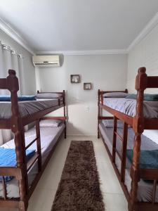 a bedroom with three bunk beds and a rug at Casa de Praia in Penha