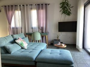 DhorizátaにあるAetheria Villa Kefaloniaの青いソファとテーブルのあるリビングルーム