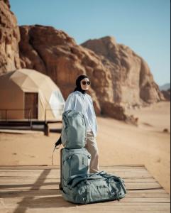 a man standing next to a bag in the desert at WADI RUM NEOM lUXURY CAMP in Wadi Rum +47 photos