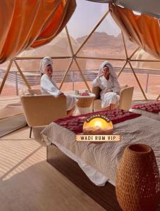 two women sitting in chairs in a room with a view at WADI RUM NEOM lUXURY CAMP in Wadi Rum