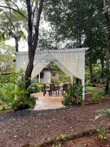 einen weißen Baldachin über einer Terrasse mit einem Tisch und Stühlen in der Unterkunft VANESSA'S GARDEN Restaurant & Bungalow in PhumÄ­ AnlÃ³ng Svay