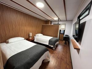 a hotel room with two beds and a television at Motherhome in Melipilla