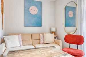 a living room with a couch and a red chair at Cocon lumineux à Bandol à deux pas de la plage et de la gare in Bandol