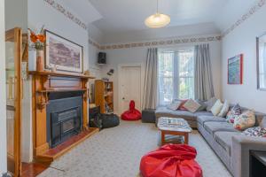 Una sala de estar con un sofá y una chimenea. en The Villa, en Picton