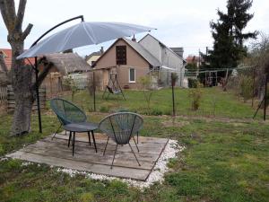a table and chairs under an umbrella in a yard at Apartments in Balatongyörök 34590 in Balatongyörök +3 photos