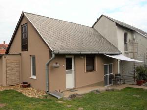 a house with a gambrel roof with a patio at Apartments in Balatongyörök 34590 in Balatongyörök