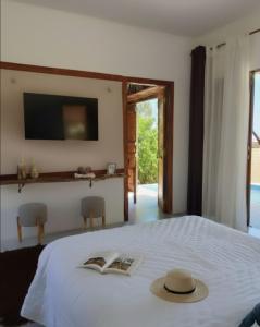 Un dormitorio con una cama con un sombrero encima. en Bangalô Exclusivo Pontal do Maceió, en Maceió 32 fotos más