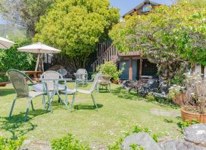 Un patio con sillas, una mesa y una sombrilla. en The Villa, en Picton