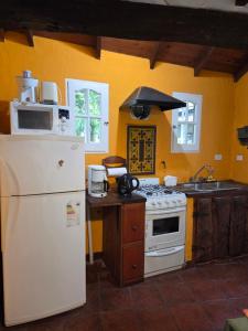 a kitchen with a white stove and a refrigerator at Casa alameda in Mar de Cobo