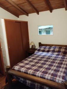 a bedroom with a bed with a plaid blanket at Casa alameda in Mar de Cobo