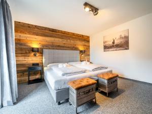 Un dormitorio con dos camas y una pared de madera. en Fernblick, en Kirchberg in Tirol 31 fotos más