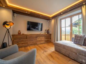 Una sala de estar con un sofá y un televisor. en Fernblick, en Kirchberg in Tirol